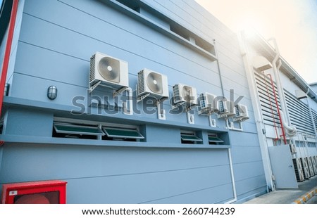 Condenser unit or compressor outside home or residential building. Unit of central air conditioner AC or heating ventilation air conditioning system HVAC. Electric fan and refrigerant pump inside.