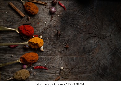 Condiment Of Mix Indian Food Explosion Spice Splash Dark Background On Wood Table Top View. Desk Asian Organic Herb Cuisine Flavour In Kitchen Board, Chilli Spicy Powder In Brass Spoon Concept