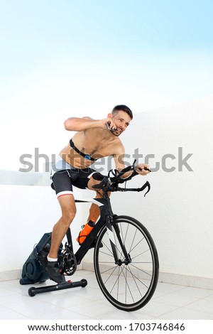 Conditioner during training. The athlete eats an energy bar riding a stationary bike
Sports training on a stationary exercise bike.
