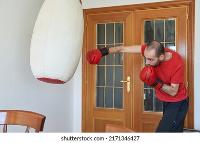 Conditioning Boxing Training At Home. Young Male Hits Jab In Living Room To Heavy Bag