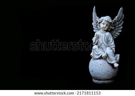 Condolence card with an angel figurine isolated on black background with copy space