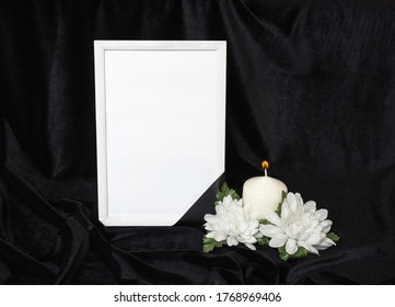 Condolence Card. Memorial Frame With Black Ribbon. White Flowers And A Burning Candle. Black Background.