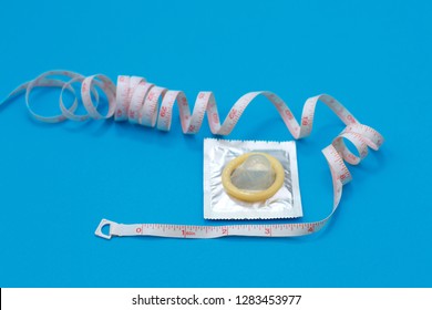 Condom And Measuring Tape In The Form Of A Penis. How To Choose The Right Condom Size. Phallus And Measure Tape, Satisfaction, Pleasure Concept.