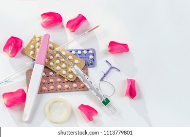 condoms and birth control pills on a white background