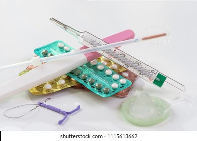 Kondome und Geburtenkontrolltabletten auf weißem Hintergrund
