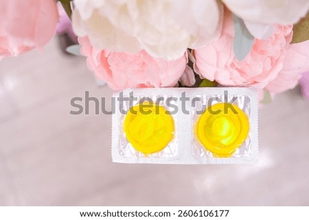 condoms are lying on a background of pink peonies, space for text. High quality photo