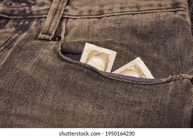 Condoms Are In The Pocket Of Ripped Black Jeans.