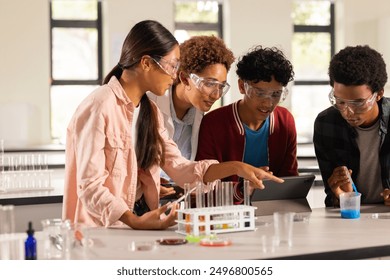 Conducting science experiment and discussing results, teenagers in high school classroom. Education, students, teamwork, learning, discussion, laboratory - Powered by Shutterstock