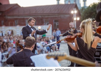 Conductor Directing Orchestra Performance On The Street