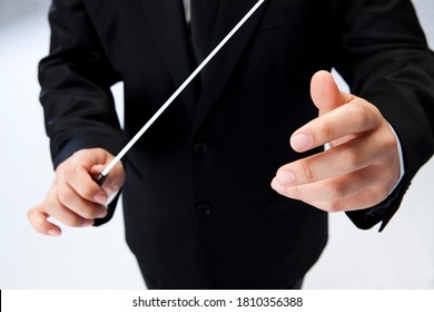 a conductor holding a baton in one hand - Powered by Shutterstock