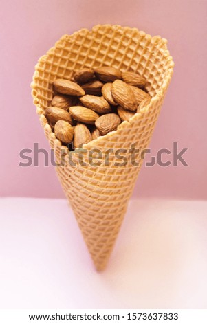 Similar – Ice cream cone with unpeeled peanuts on pink background