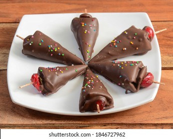 cone shaped chocolate flavored betel leaf on ice stuffed with cherry known as chocolate paan. A widely loved mouth-freshener cum dessert recipe with selective focus
