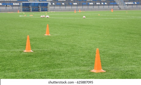 Cones And Balls For Football Training At The Stadium. Sports Background. Artificial Lawn On A Soccer Field. 