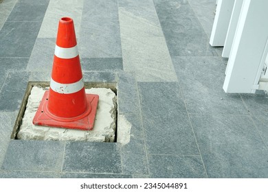 A cones on the pathwalk floor to protect was  fixxing a broken drain. 