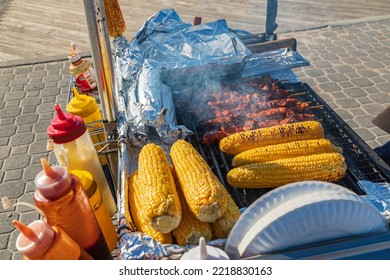 Coney Island, Brooklyn, New York, USA. Meat Kebabs And Corn On The Cob At A Sidewalk Food Stand.