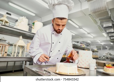 A Confectioner With A Cake In The Bakery.