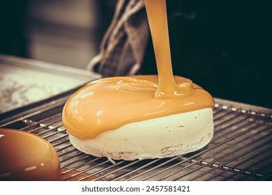 Confectioner covers tart with a liquid orange glaze. Preparation of the tart by a professional pastry chef. - Powered by Shutterstock