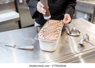 Confectioner pouring chocolate on the ice cream, making ice cream on the kitchen of a small manufacturing or restaurant, close-up - Shutterstock ID 1775018546