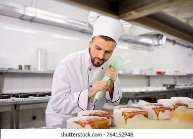 The confectioner is preparing a cake in the kitchen of the pastr