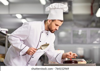 The confectioner is preparing a cake in the kitchen of the pastr