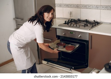 Confectioner Takes The Finished Cake Out Of The Oven.