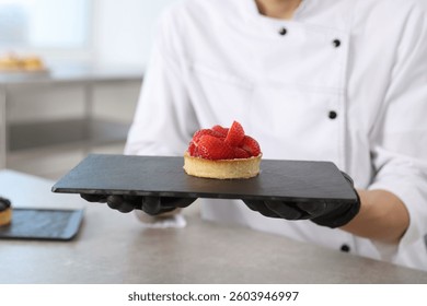 Confitero con sabrosa tarta en la mesa gris en la cocina, en primer plano