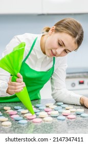 Сonfectioner With Confectionery Bag Squeezing Cream Filling To Macarons Shells 