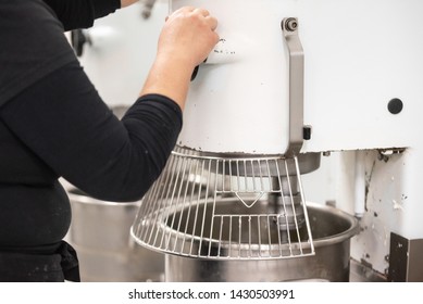 Confectionery factory worker standing and operating industrial dough mixer machine . - Powered by Shutterstock