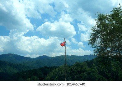 A Confederate Flag Flying Atop A Tree Trunk