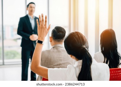 Conference attendees raise their hands for questions, showcasing interactive engagement. A diverse audience collaborates at a workshop or seminar, highlighting teamwork and discussion. - Powered by Shutterstock