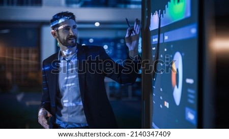 Conference Business Meeting Presentation: CEO Businessman Shows Data to Group of Investors, Businessspeople. Projector Screen Shows Graphs, Product Sales, Revenue Growth Strategy, e-Commerce Analysis