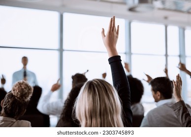 Conference, crowd and business people with hands for a question, vote or volunteering. Corporate event, meeting and hand raised in a training seminar for questions, voting or audience opinion