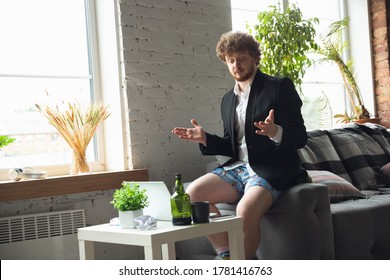 Conference, Meeting. Man Without Pants But In Jacket Working On A Computer, Laptop. Remote Office During Coronavirus, Fun And Comfortable In Underpants. Insulation, Quarantine, Humor, Business Concept