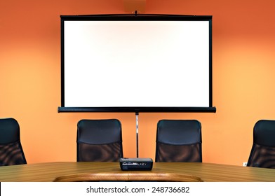Conference room with empty chairs and a projector screen