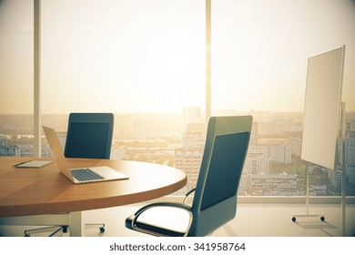 Conference room with wooden table with laptop and blackboard at sunset 3D Render