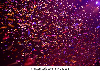 Confetti Fired On Air During A Concert. People Are Happy And With Hands In The Air. Image Ideal For Backgrounds. Pink And Purple Are The Tones Of The Picture
