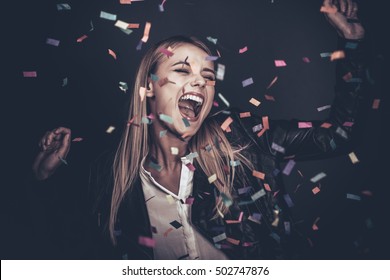 Confetti fun. Beautiful young woman throwing confetti and looking happy 