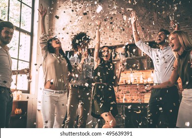 Confetti fun. Group of happy young people throwing confetti and jumping while enjoying home party on the kitchen  - Shutterstock ID 495639391
