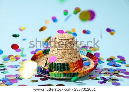 Confetti and hat on blue background, close up
