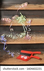 Confetti And Ribbons On Wood Steps And A Dust Pan - Cleaning Up After The Party