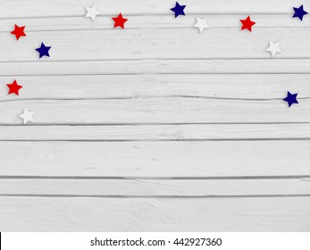 Confetti stars on wooden background. 4th July, Independence day, card, invitation in usa flag colors. Top view, empty space.