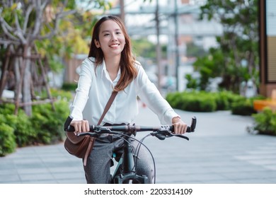 Confidence of Asian businesswoman go to office work at modern city street with bicycle, Eco friendly in the morning business female using bike concept. - Powered by Shutterstock