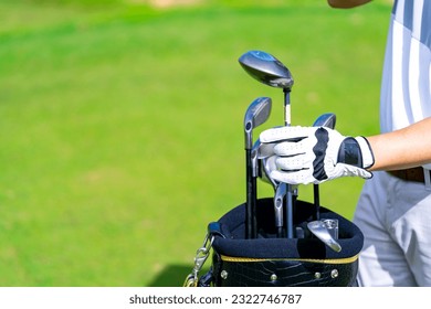 Confidence Asian man golfer choosing golf club in golf bag for golfing on golf course fairway. Healthy people enjoy outdoor activity lifestyle sport training at country club on summer holiday vacation - Powered by Shutterstock