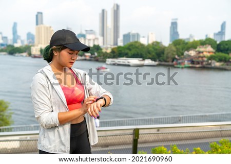 Confidence Asian woman in sportswear jogging on the bridge in the city. Healthy female athlete enjoy outdoor lifestyle activity do sport training workout fitness exercise running in summer morning.