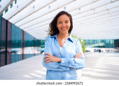 Confidence Businesswoman portrait with crossed hands. Pretty business woman 30 years old standing near office building dressed blue shirt. Caucasian female business person outside - Shutterstock ID 2184992671
