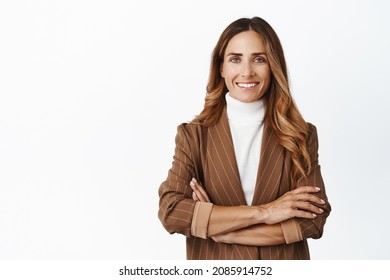 Confident adult businesswoman. Smiling woman ceo cross arms on chest, looking like real professional, wearing brown stylish suit, white background
