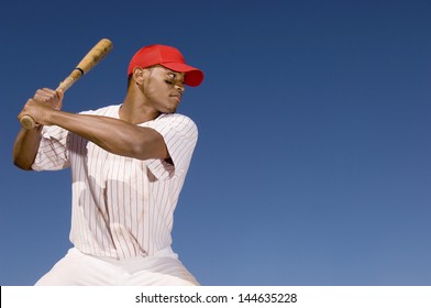 Confident African American baseball batter waiting to strike the ball