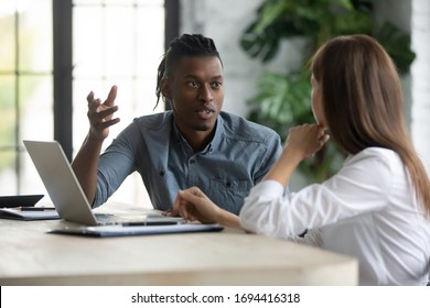 Confident african american businessman talking with businesswoman in boardroom at meeting. Employee presenting new business concept for female boss discuss. Team together using laptop. - Shutterstock ID 1694416318
