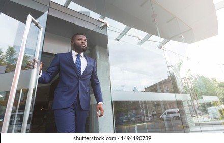 Confident African American Employee In Formal Suit Walking Out Of Business Center, Low Angle View