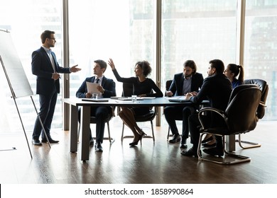 Confident African American Female Employee Raise Hand Interact At Company Presentation Meeting In Office. Smiling Biracial Woman Ask Answer Question At Educational Training Or Briefing With Coach.